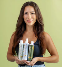  A woman holds three Ingreendients’ sulfate-free, plant-based shampoo and conditioner bottles.